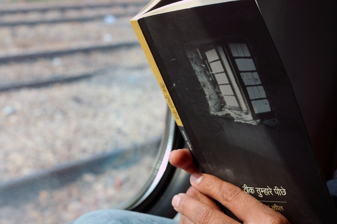 Person reading a book quietly by a window